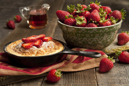 Freshly baked cake and a bowl of strawberries