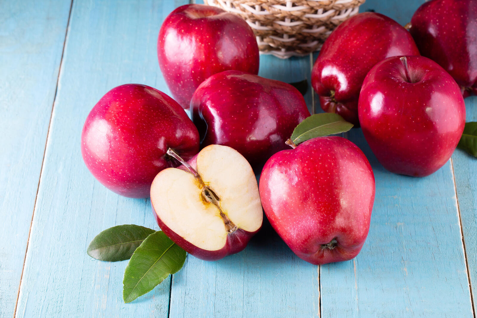 Бесплатное фото Красные яблоки на голубом фоне