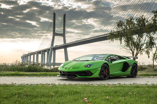 Зеленая SVJ Lamborghini Aventador на фоне моста