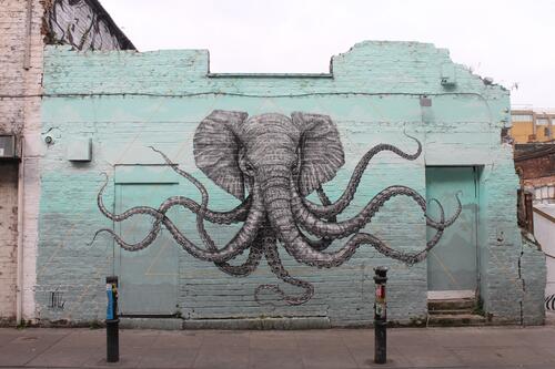 Граффити слона на кирпичной стене