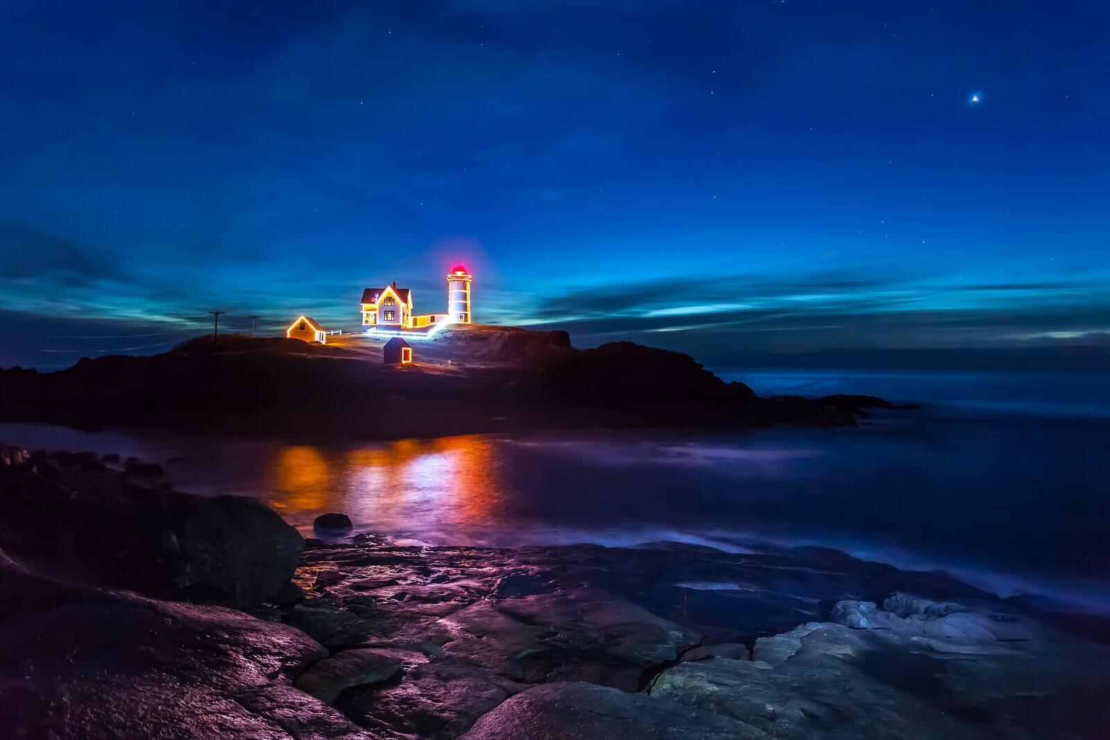 免费照片海岸上的夜间灯塔