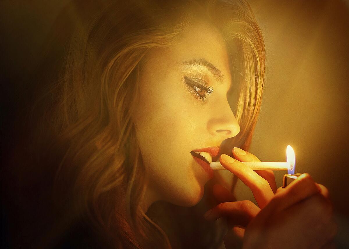 A girl lights a cigarette