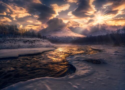 Winter river and mountains at sunset