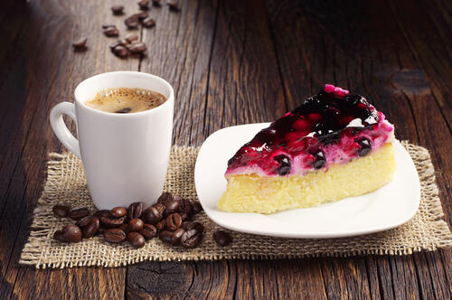 A piece of berry cake and cup of coffee