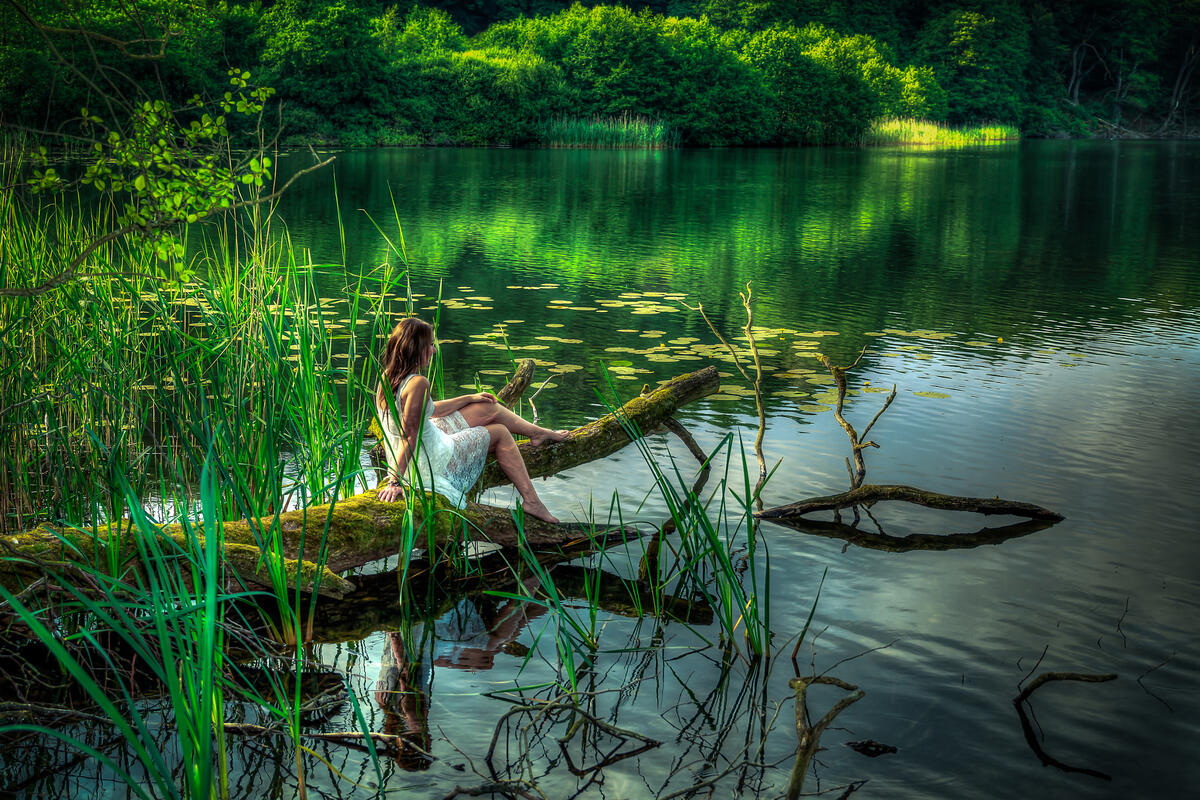 Одинокая девушка на берегу реки