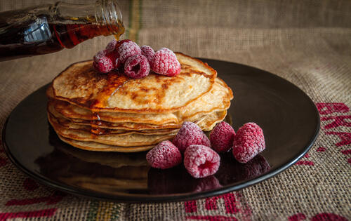 Pancakes with syrup and raspberries