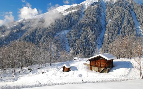 Старый дом зимой у подножья горы
