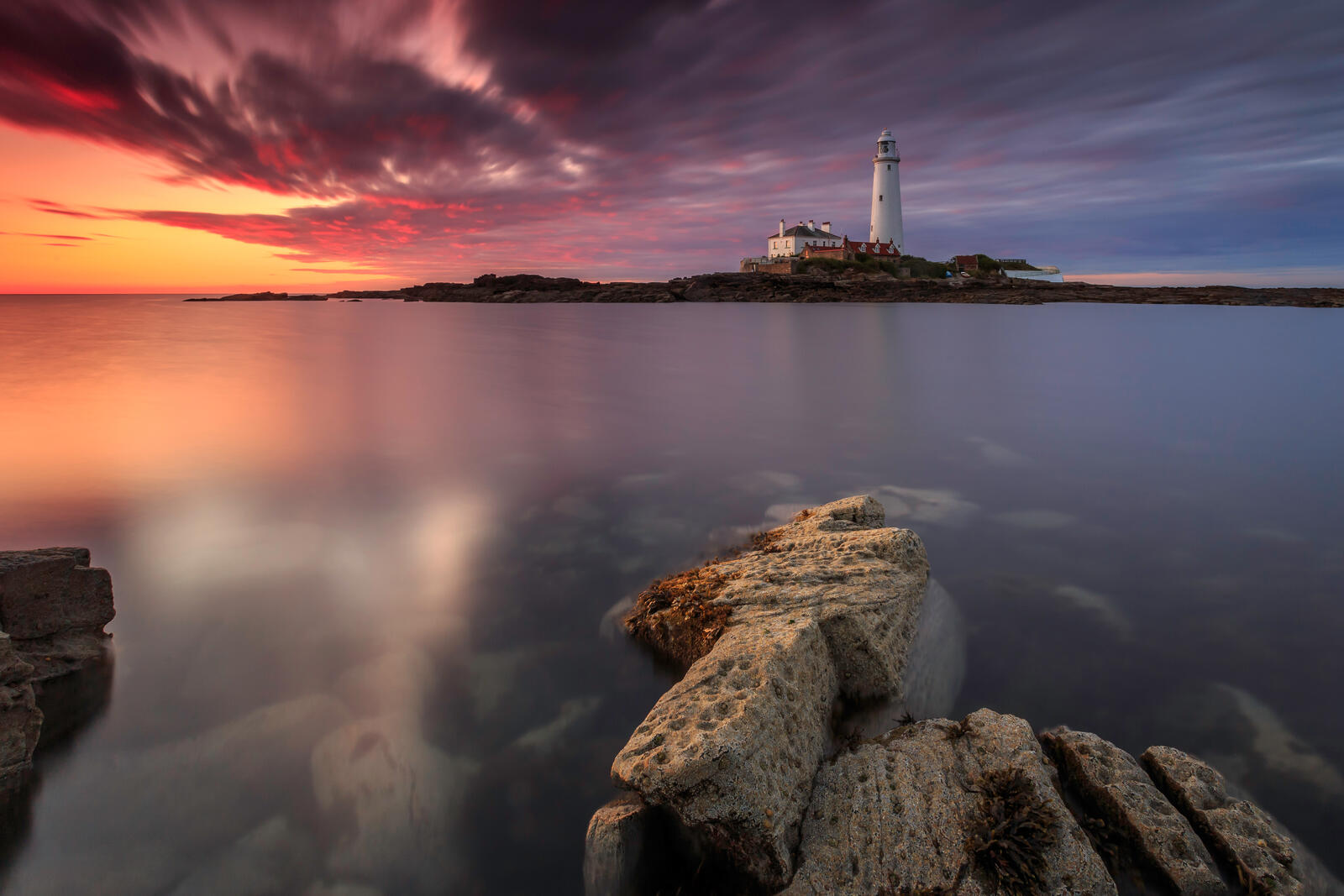 Бесплатное фото Вид на маяк с каменистого берега