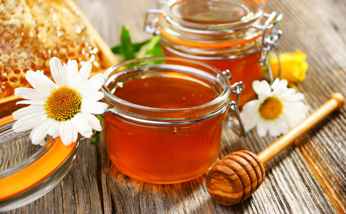 Honey in jars and chamomile