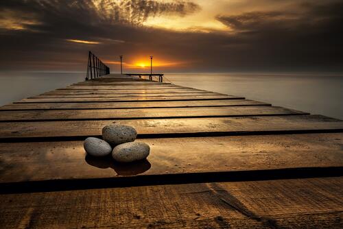Three stones on a wooden pier